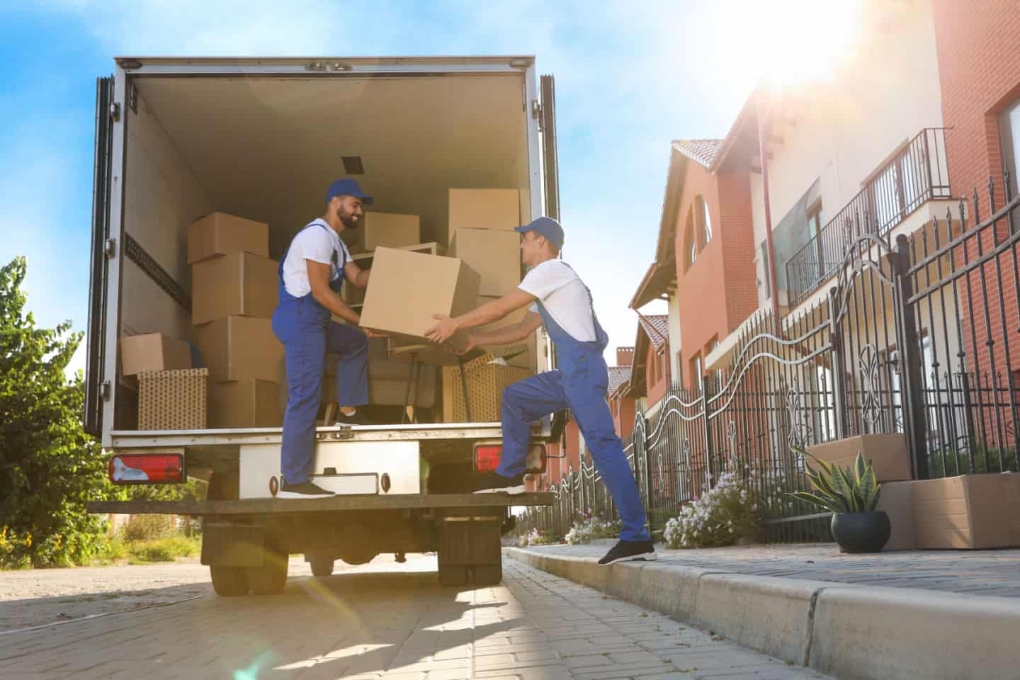 Two movers placing boxes in a moving truck