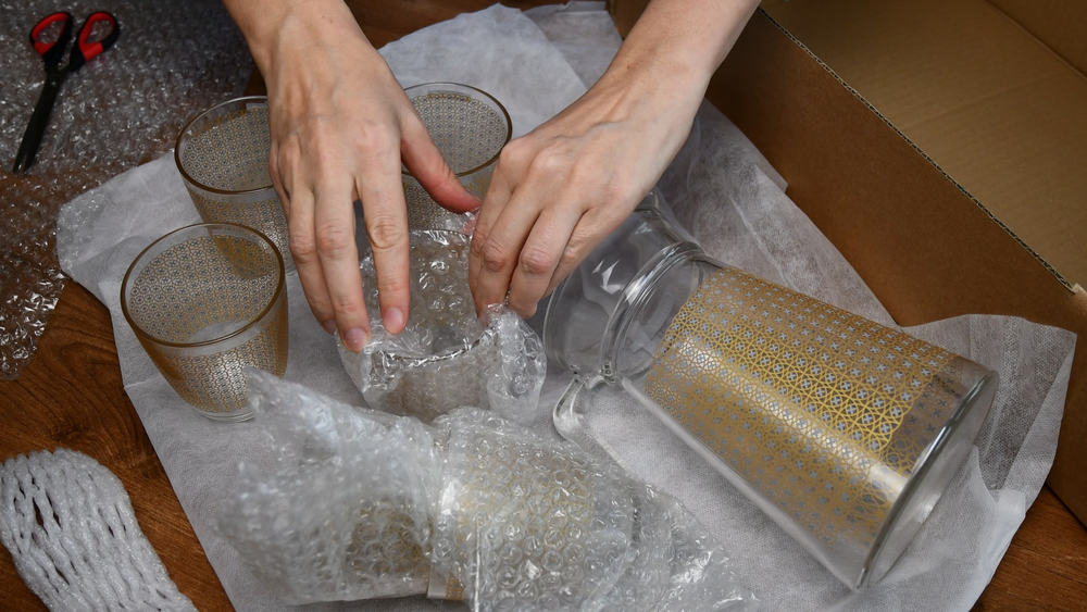 Woman,Hands,Pack,Up,Fragile,Glassware,Into,Wrapping,Bubble,Plastic