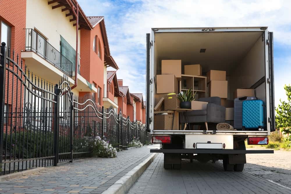 Van,Full,Of,Moving,Boxes,And,Furniture,Near,House