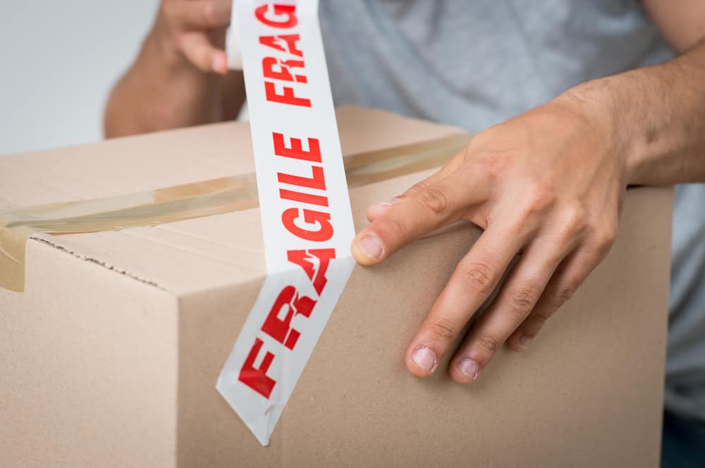 Close,Up,Of,A,Man,Packing,Cardboard,Box,With,Sellotape